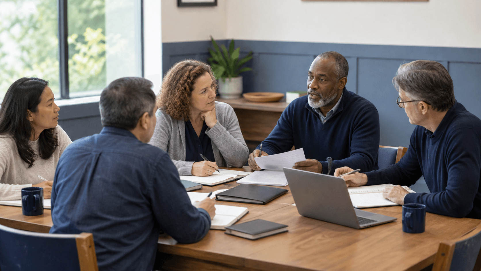 Investment club members reviewing a meeting agenda around a table